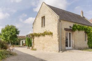 a brick building with vines on the side of it at Le Relais des Flâneurs in Thaon