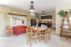 a dining room and living room with a table and chairs at Le Relais des Flâneurs in Thaon +11 photos