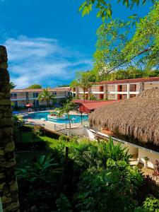 a resort with a swimming pool and a building at Hotel Plaza Palenque in Palenque