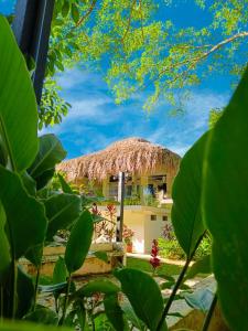 a resort with a straw hut in the background at Hotel Plaza Palenque in Palenque