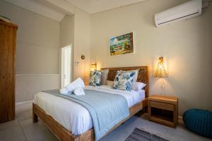 a bedroom with a bed with blue and white pillows at Villa Pwani in Baie du Tombeau +85 photos