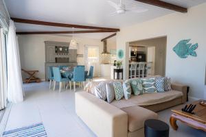 a living room with a couch and a dining room at Villa Pwani in Baie du Tombeau