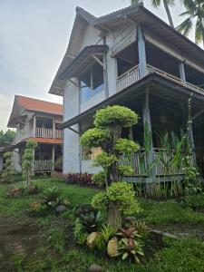 a house with a tree in front of it at AgaLiving Medewi in Pulukan