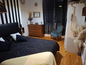 ein Schlafzimmer mit einem Bett, einem Stuhl und einer Kommode in der Unterkunft Caro in Eu