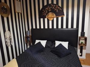 ein Schlafzimmer mit einer schwarz-weiß gestreiften Wand und einem Bett in der Unterkunft Caro in Eu