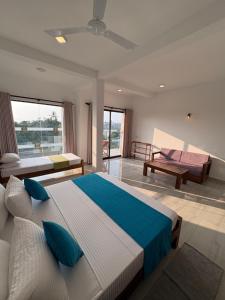 a bedroom with a large bed with blue pillows at Crossing Royal in Mirissa