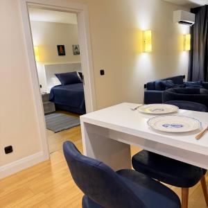 a living room with a white table and blue chairs at EVIS LTD apartments Batumi 2 in Angisa