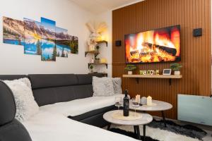 a living room with a couch and a fire painting on the wall at Apartman Bn Vlasic in Vlasic