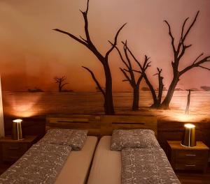 two beds in a room with a mural of trees at Studio/Loft in Eberswalde in Eberswalde
