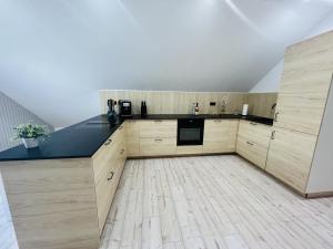a large kitchen with wooden cabinets and a wooden floor at Spacious home in quiet surroundings in Schwanden