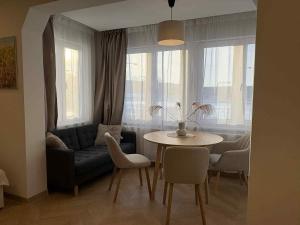 a living room with a couch and a table at Cozy city centre apartment in Telšiai
