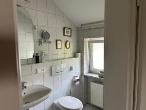 a white bathroom with a sink and a toilet at Gemütliche Wohnung in Baldham bei München in Vaterstetten +31 photos