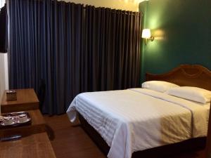 a bedroom with a bed and a green wall at Nina Hotel Syariah in Salatiga