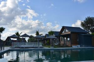 a resort with a swimming pool and a house at Palm Garden in Korucuk
