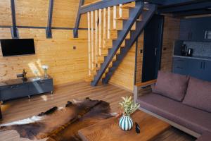 a living room with a couch and a staircase at Palm Garden in Korucuk