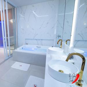 a white bathroom with a sink and a bath tub at Motel Você Que Sabe Temático Deluxe in Cacoal +76 photos