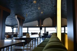 a restaurant with tables and chairs and a couch at Palm Garden in Korucuk +55 photos