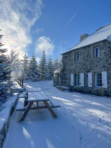 a picnic table in the snow in front of a building at La Grangette de Barbe in Le Béage