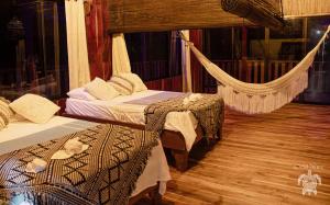 a room with two beds and a hammock at Casa Shec- An Oceanfront Jungle Retreat in Drake