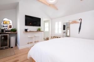 a white bedroom with a bed and a bar at sisu, a boutique motel in Plymouth