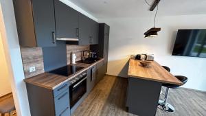 a kitchen with gray cabinets and a wooden counter top at Ferienwohnung Wiesenweg - Aktiv im Allgäu in Seeg