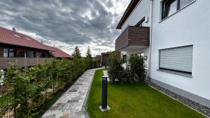 a house with a grassy yard next to a building at Ferienwohnung Wiesenweg - Aktiv im Allgäu in Seeg