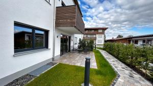 a house with a small yard with a lawn at Ferienwohnung Wiesenweg - Aktiv im Allgäu in Seeg +8 photos
