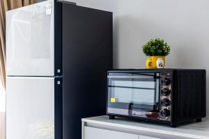 a microwave sitting on a counter next to a refrigerator at SPACIOUS AND BRIGHT 2BR TownHouse7 MonkeyHill in Ban Sam Kong