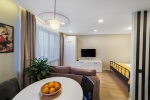 a living room with a couch and a table with oranges on it at Stilinga studija su visais patogumais in Šiauliai