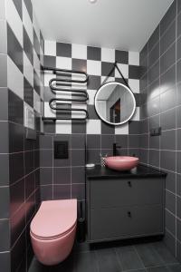 a bathroom with a pink toilet and a sink at Stilinga studija su visais patogumais in Šiauliai