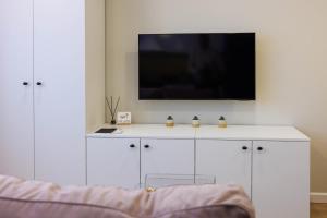 a white cabinet with a tv on top of it at Stilinga studija su visais patogumais in Šiauliai +6 photos