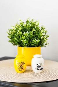 three yellow vases sitting on a table with a plant at SPACIOUS AND BRIGHT 2BR TownHouse7 MonkeyHill in Ban Sam Kong