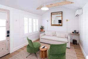 a living room with a couch and chairs and a mirror at sisu, a boutique motel in Plymouth