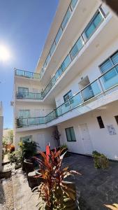 a large building with a balcony and some plants at Quinta Santa Anita in Playa del Carmen