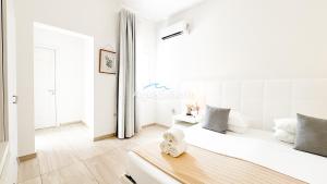 a white bedroom with a bed and a window at AQUARAMA Rooms & Apartments in Torre Squillace