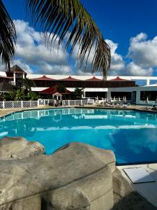 a large blue swimming pool with a building in the background at PARADISIAC LAGOON in Saint-François
