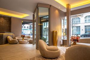 a lobby with couches and chairs in a building at Adrett Hotel Königsallee in Düsseldorf