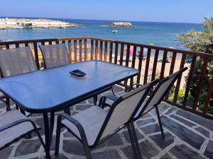 a blue table and chairs on a balcony with the ocean at Dafnis beach house in Karavostamo