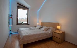 a bedroom with a bed and a window and a lamp at Lara Mezonet Tatry in Veľká Lomnica