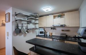 a kitchen with wooden cabinets and a black counter top at Lara Mezonet Tatry in Veľká Lomnica