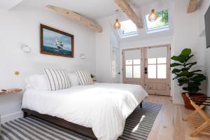 a bedroom with a large bed with white sheets at sisu, a boutique motel in Plymouth