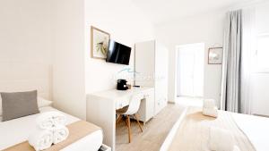 a white bedroom with a desk and a bed at AQUARAMA Rooms & Apartments in Torre Squillace