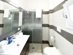 a bathroom with a glass shower and a sink at AQUARAMA Rooms & Apartments in Torre Squillace