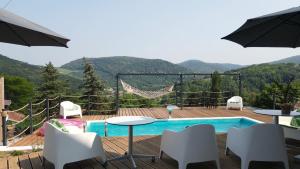 a patio with a table and chairs and a swimming pool at Vila na Vrhu in Rakovac