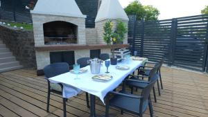 a table and chairs on a deck with a fireplace at Vila na Vrhu in Rakovac