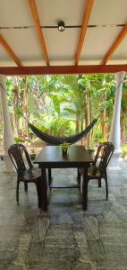 a hammock on a porch with two chairs and a table at Bakery Family Guest House in Mirissa
