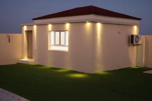 a house with lights on the side of it at شالية مزايا الاشخرة in Al Sharqiyah +3 photos