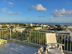 a balcony with a chair and a view of a city at Flamboyant in Sainte-Anne