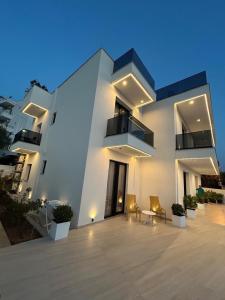 a large white building with chairs in front of it at Private Villa Ksamil in Ksamil