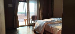 a bedroom with a bed and a sliding glass door at Agastya Beach House in Ullāl +22 photos